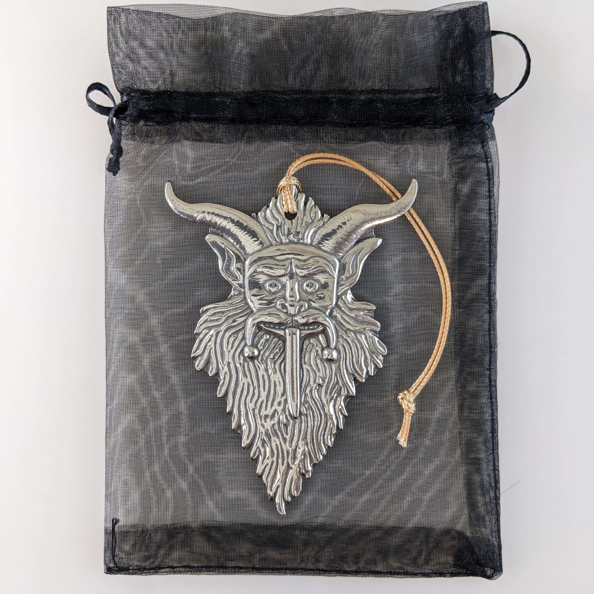 Silver goat head pendant with horns on a sheer black drawstring bag.