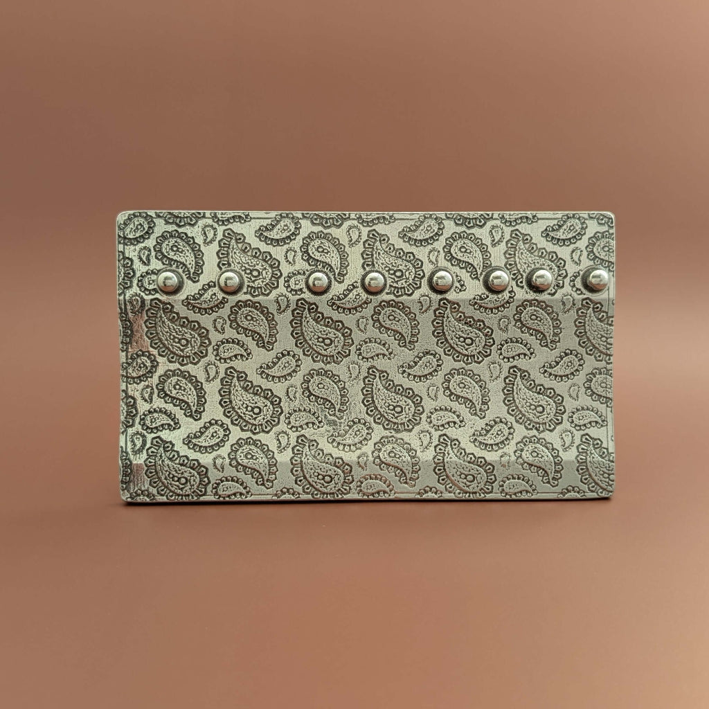 Paisly spoon display stand on brown background