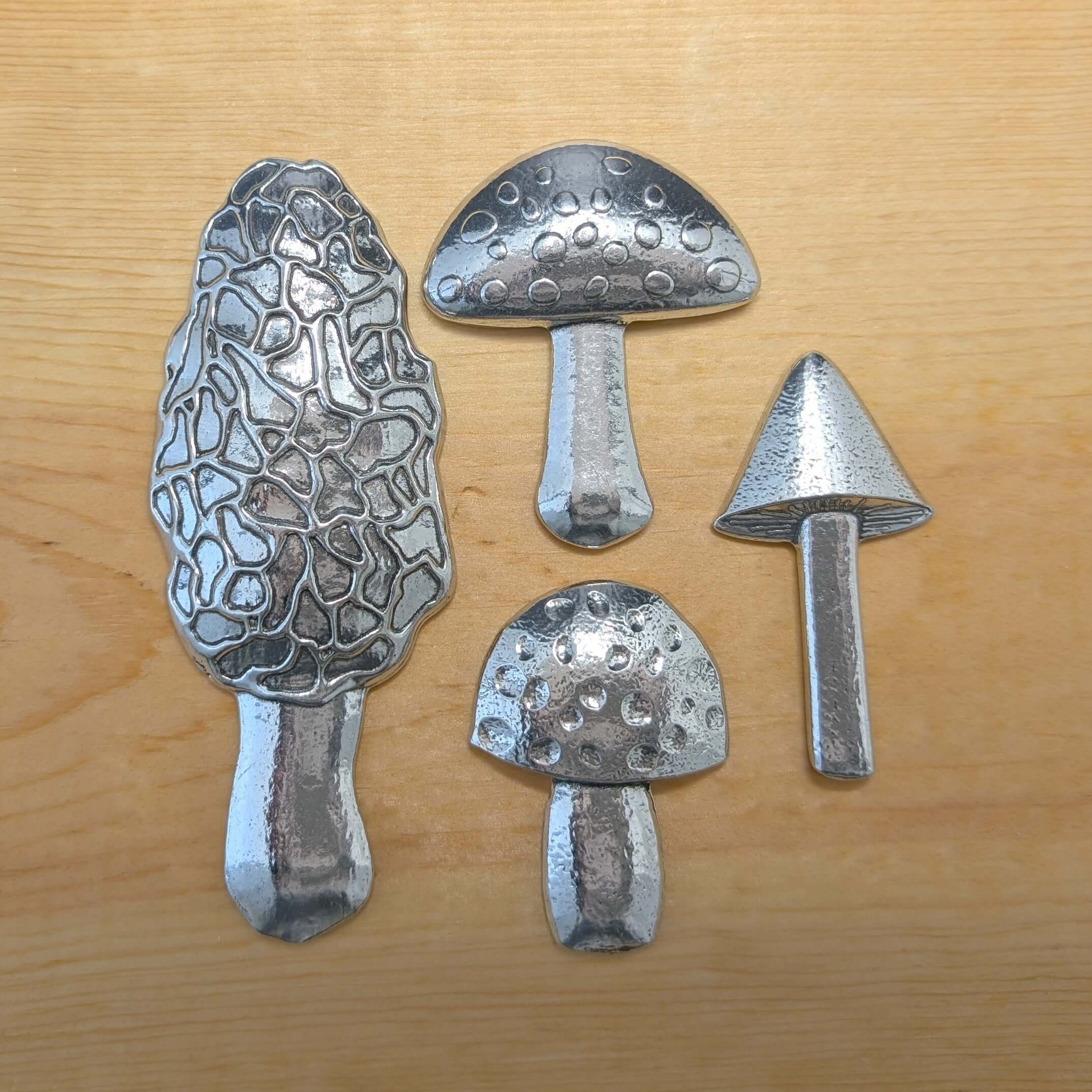 Pewter mushroom measuring spoons on wood background