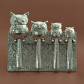 Pewter owl measuring spoons on brown background