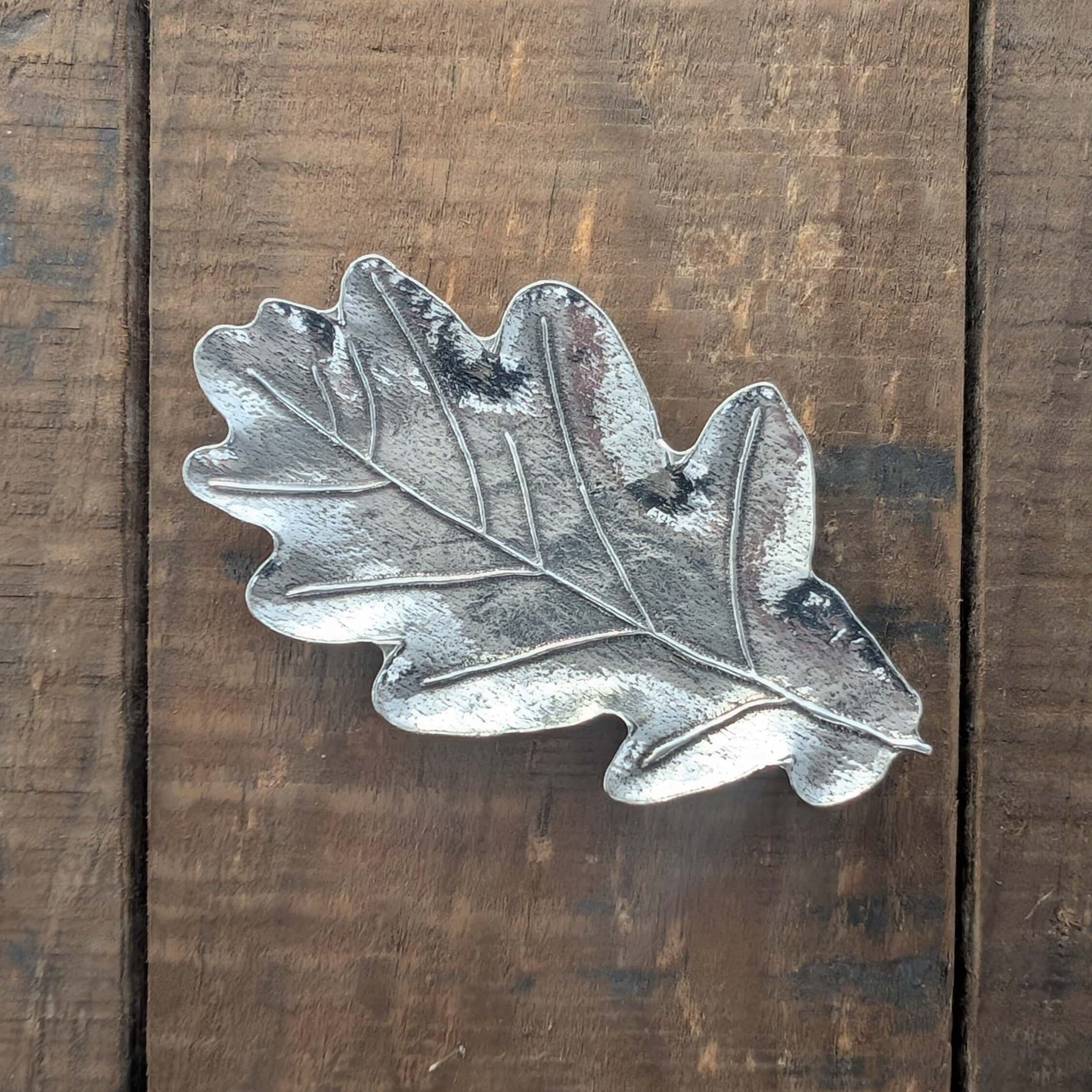 Pewter oak leaf ring dish on wood surface