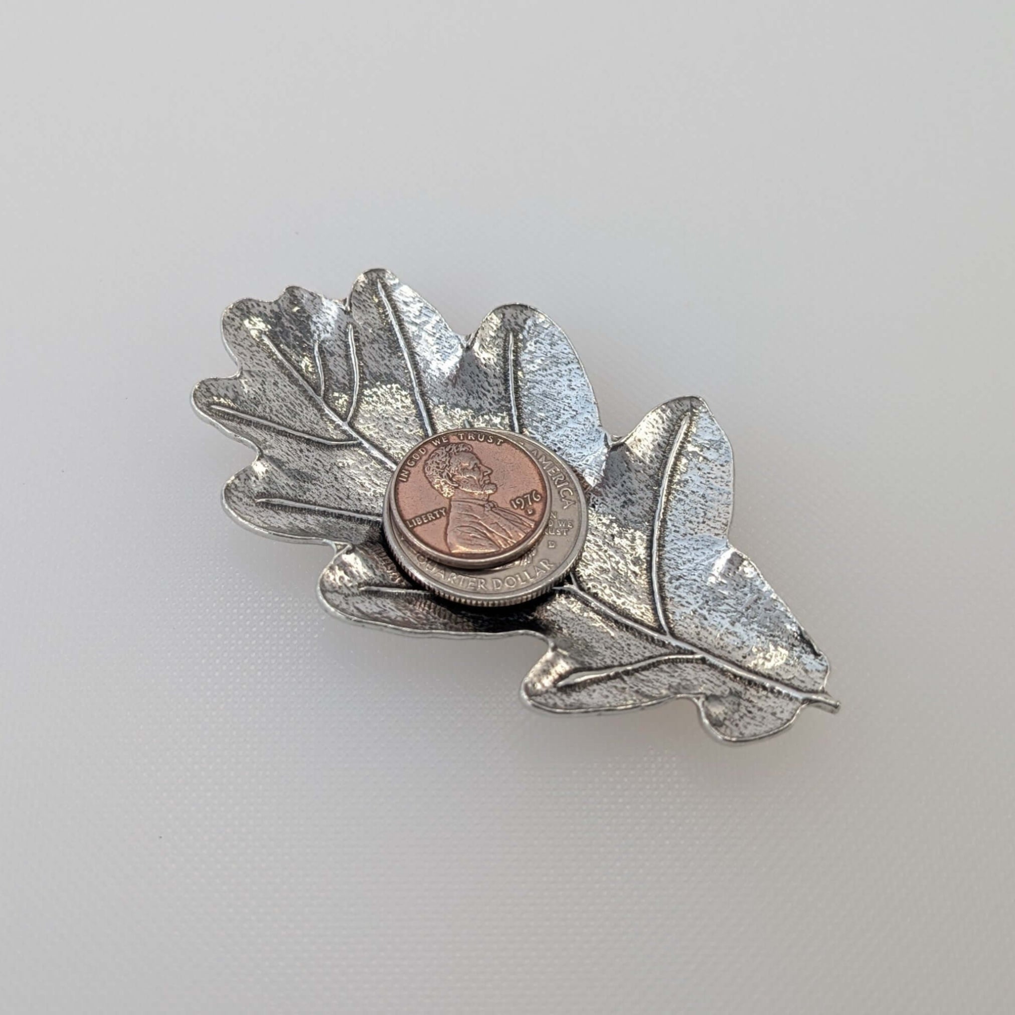 Pewter oak leaf ring dish on white surface