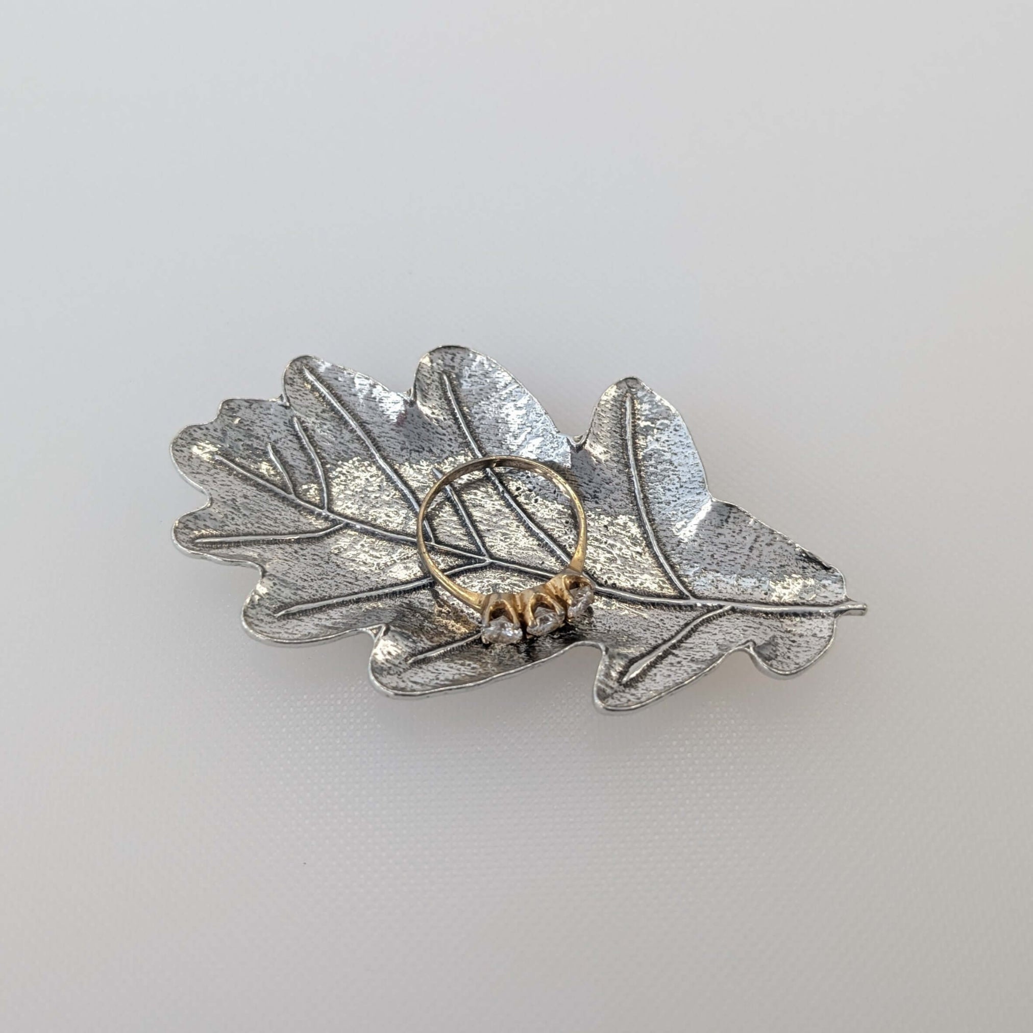 Pewter oak leaf ring dish on white surface
