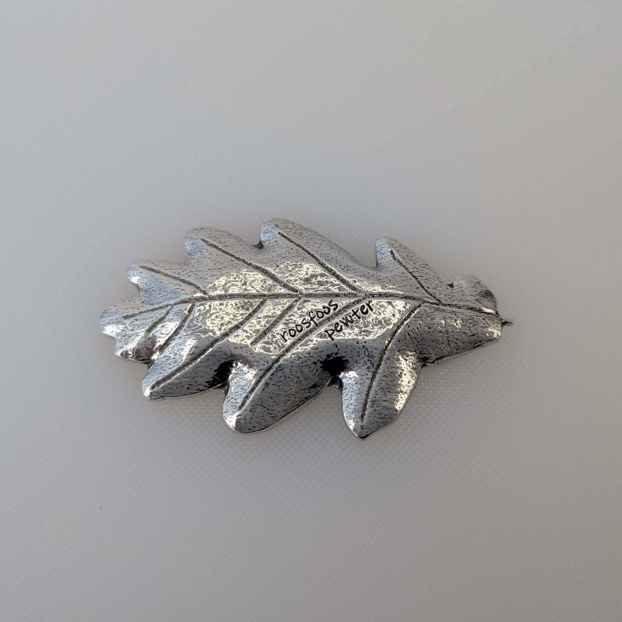 Pewter oak leaf ring dish on white surface