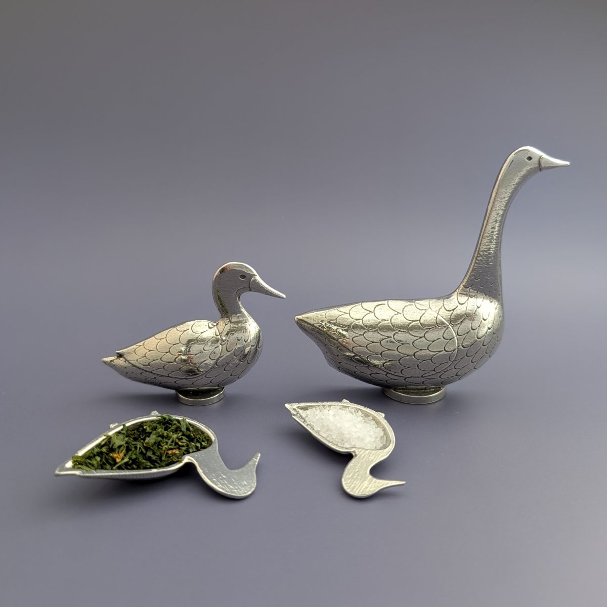 Pewter goose and duck spoons with blue background