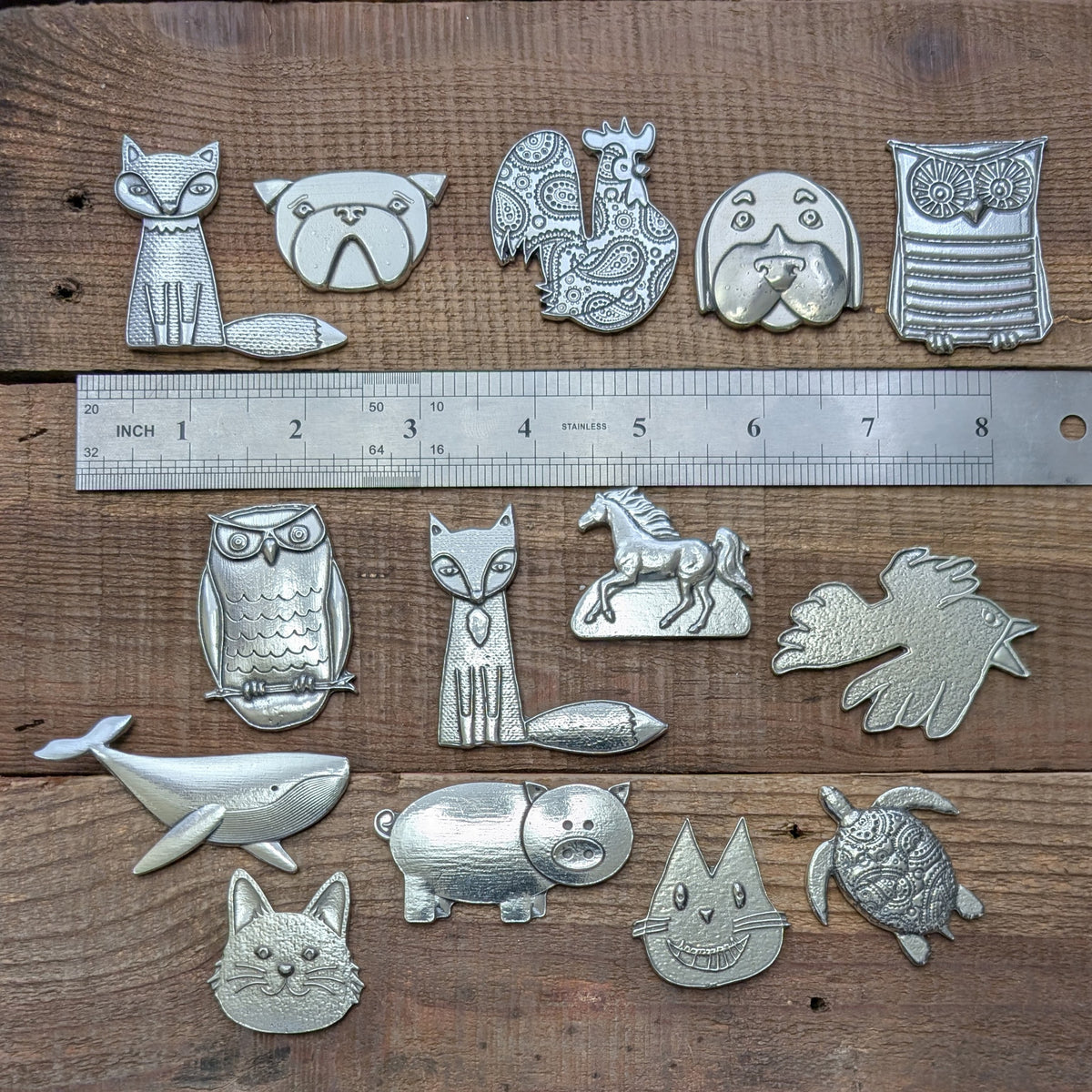 Roosfoos pewter animal magnets shown with a ruler for scale