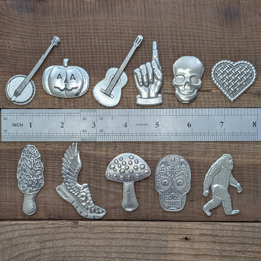 Roosfoos assorted pewter magnets shown with a ruler for scale