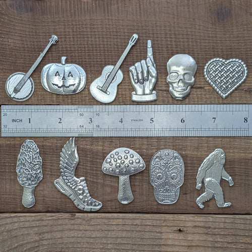 Roosfoos assorted pewter magnets shown with a ruler for scale