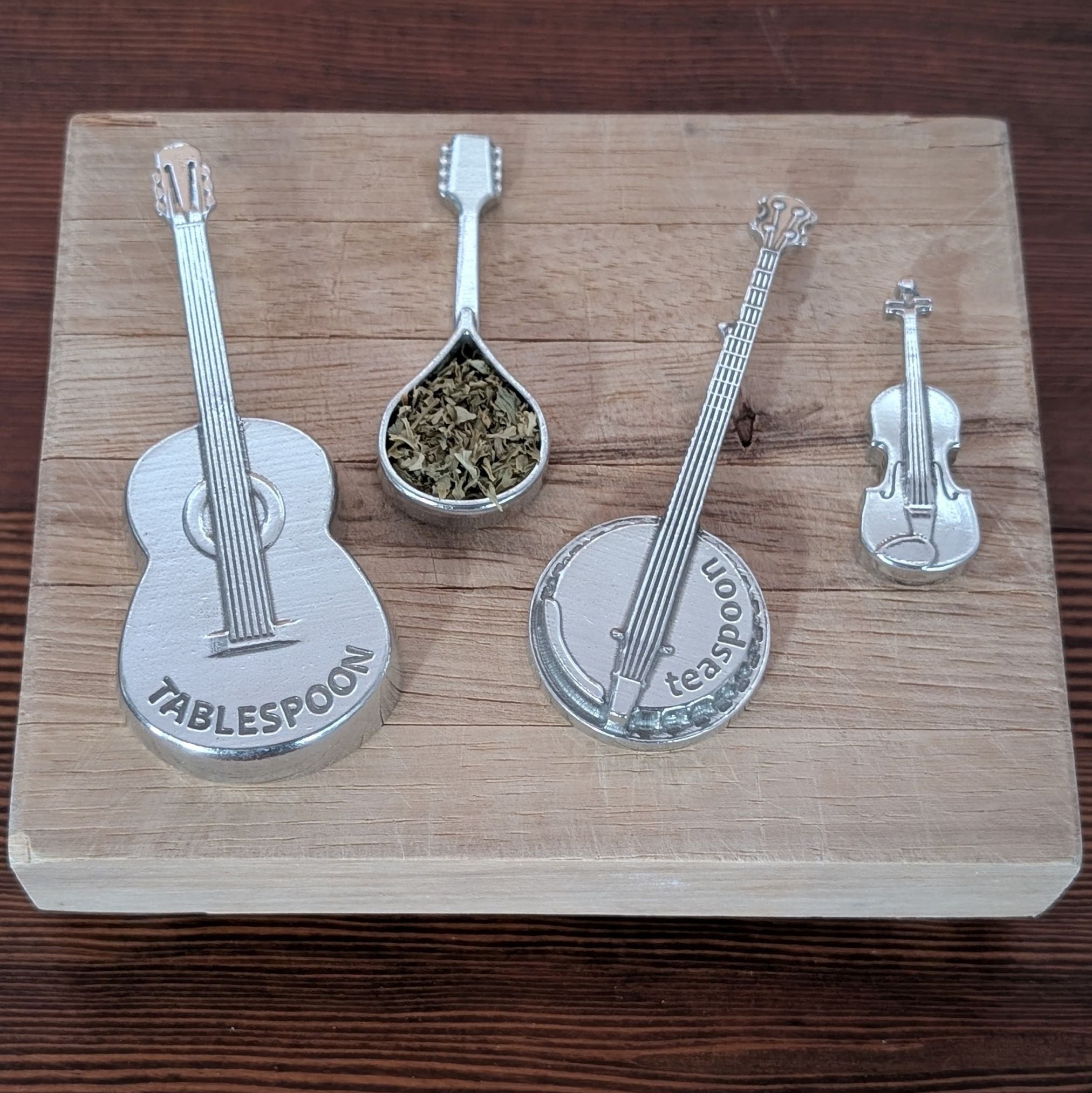 Set of musical instrument-themed measuring spoons on a wooden board