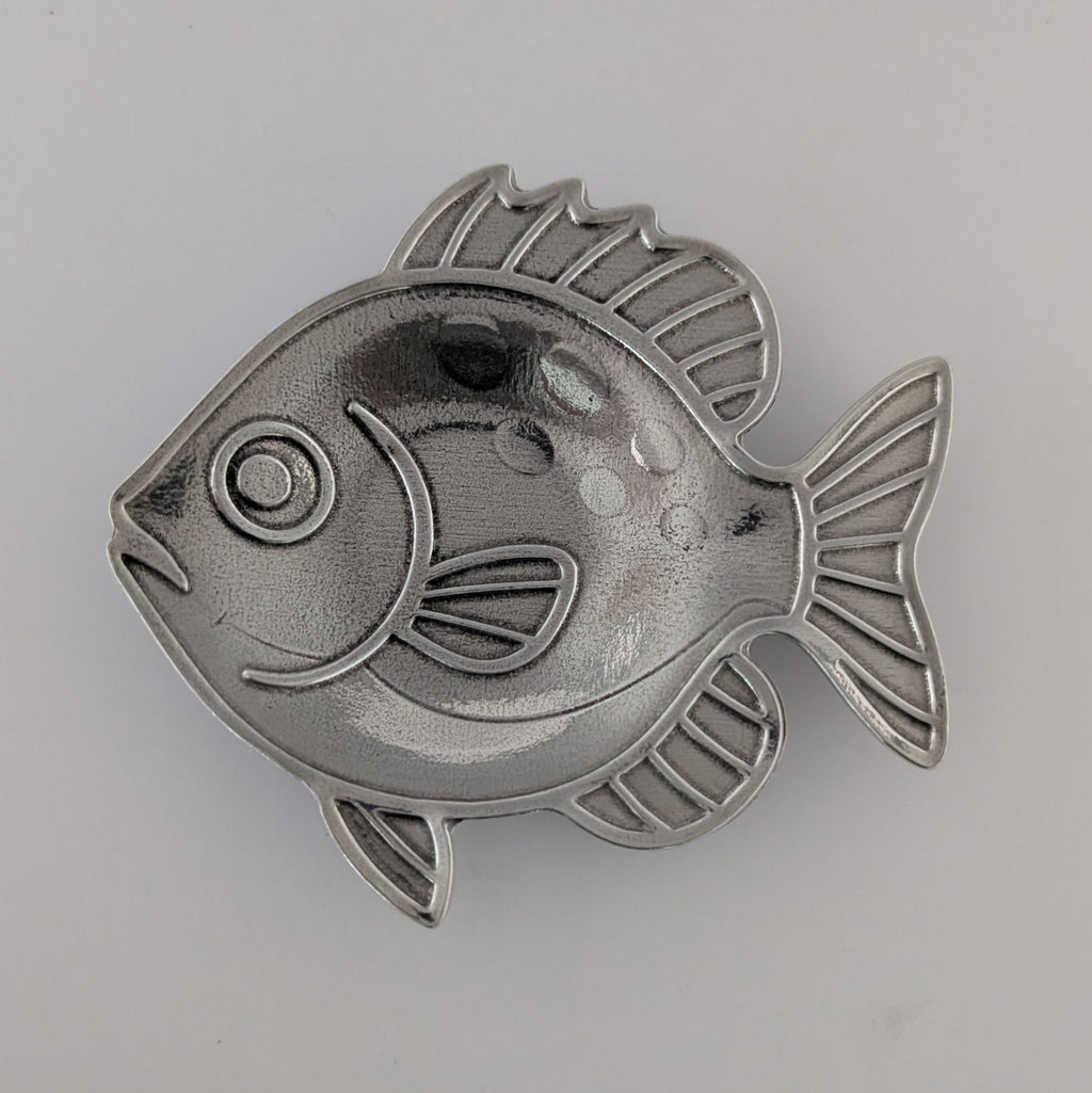 Metallic fish-shaped object on a gray background