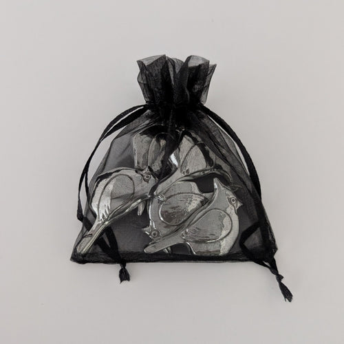 Black drawstring bag with silver birds on a light gray background