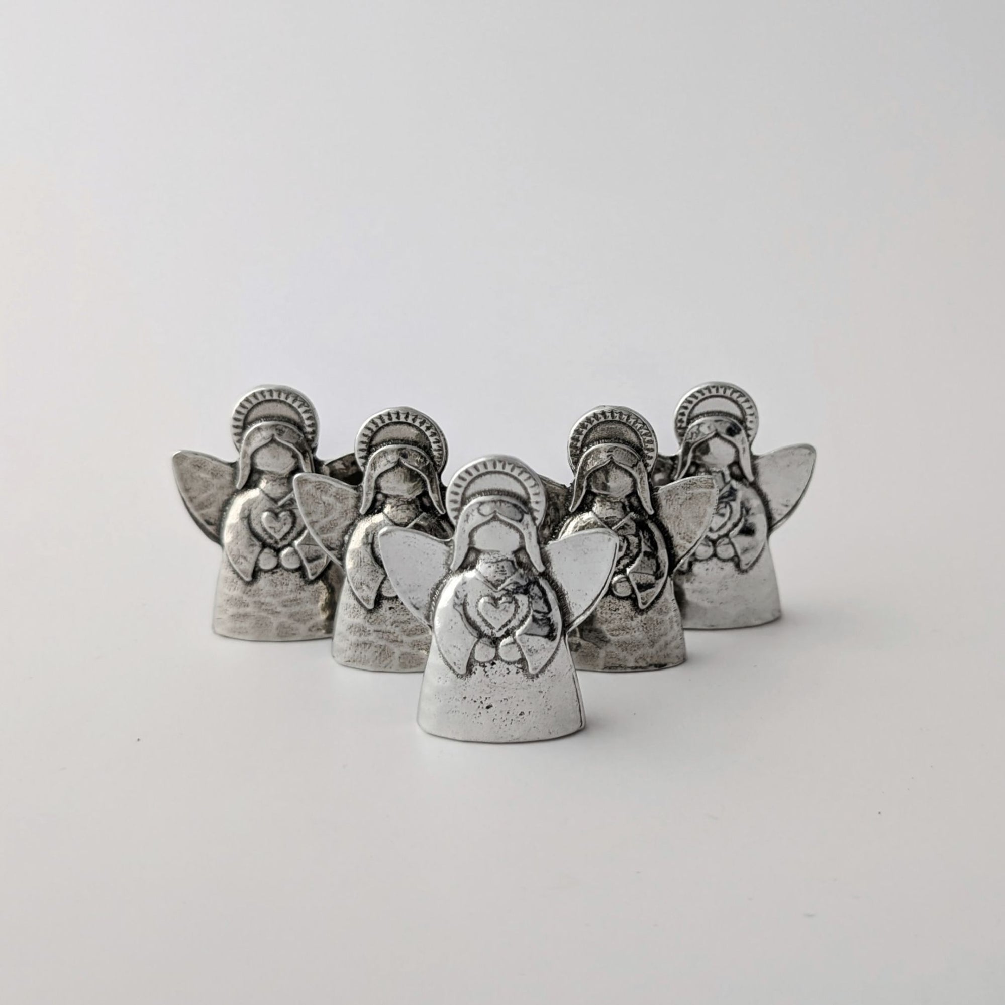 Set of five silver angel figurines on a white background