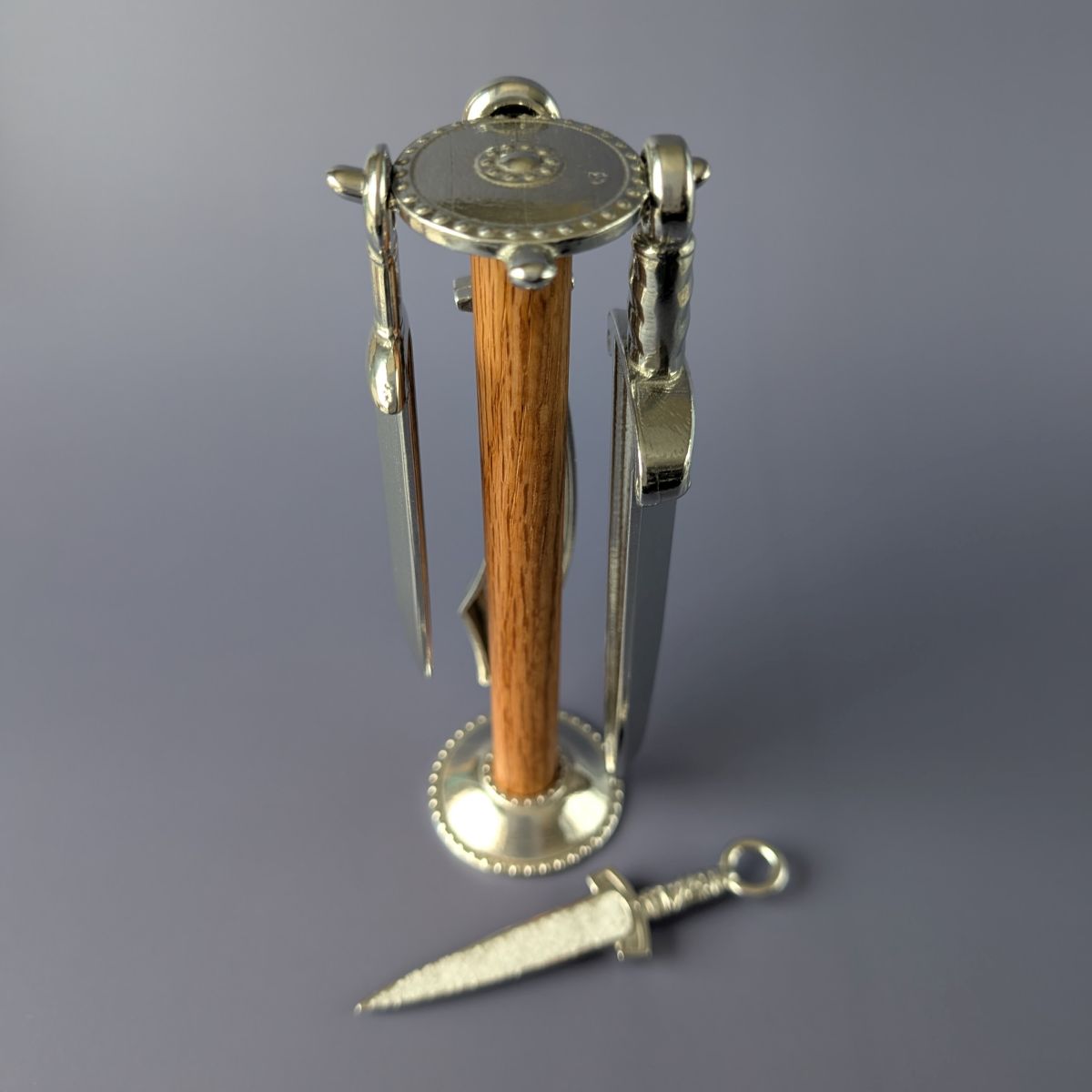 Pewter measuring spoons shaped like swords on wooden post