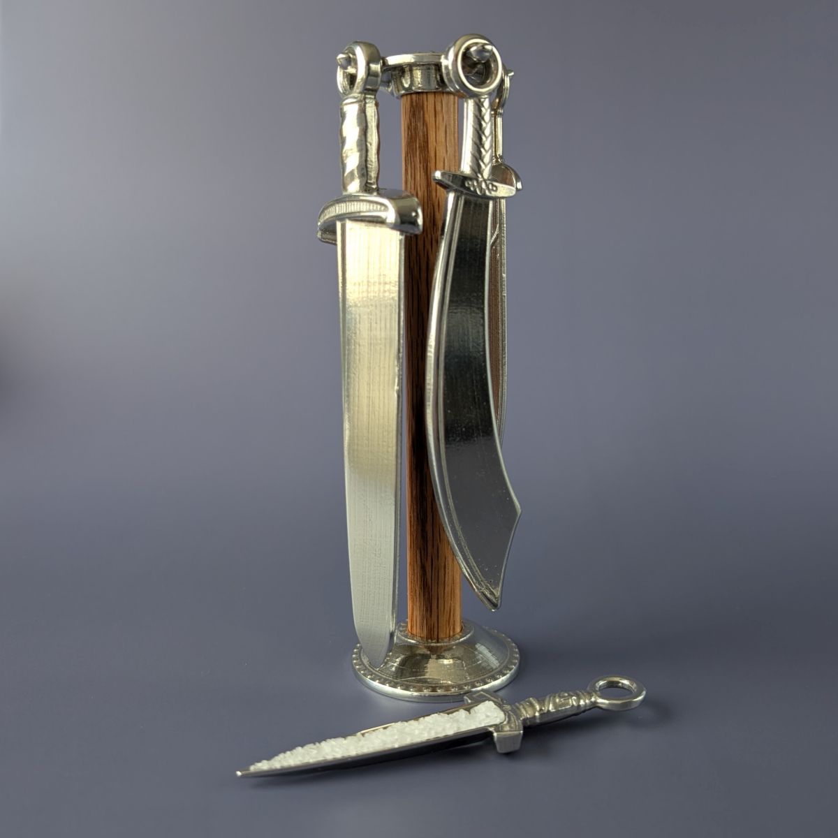 Pewter measuring spoons shaped like swords on wooden post