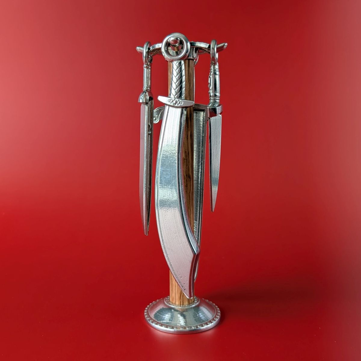 Pewter measuring spoons shaped like swords on wooden post