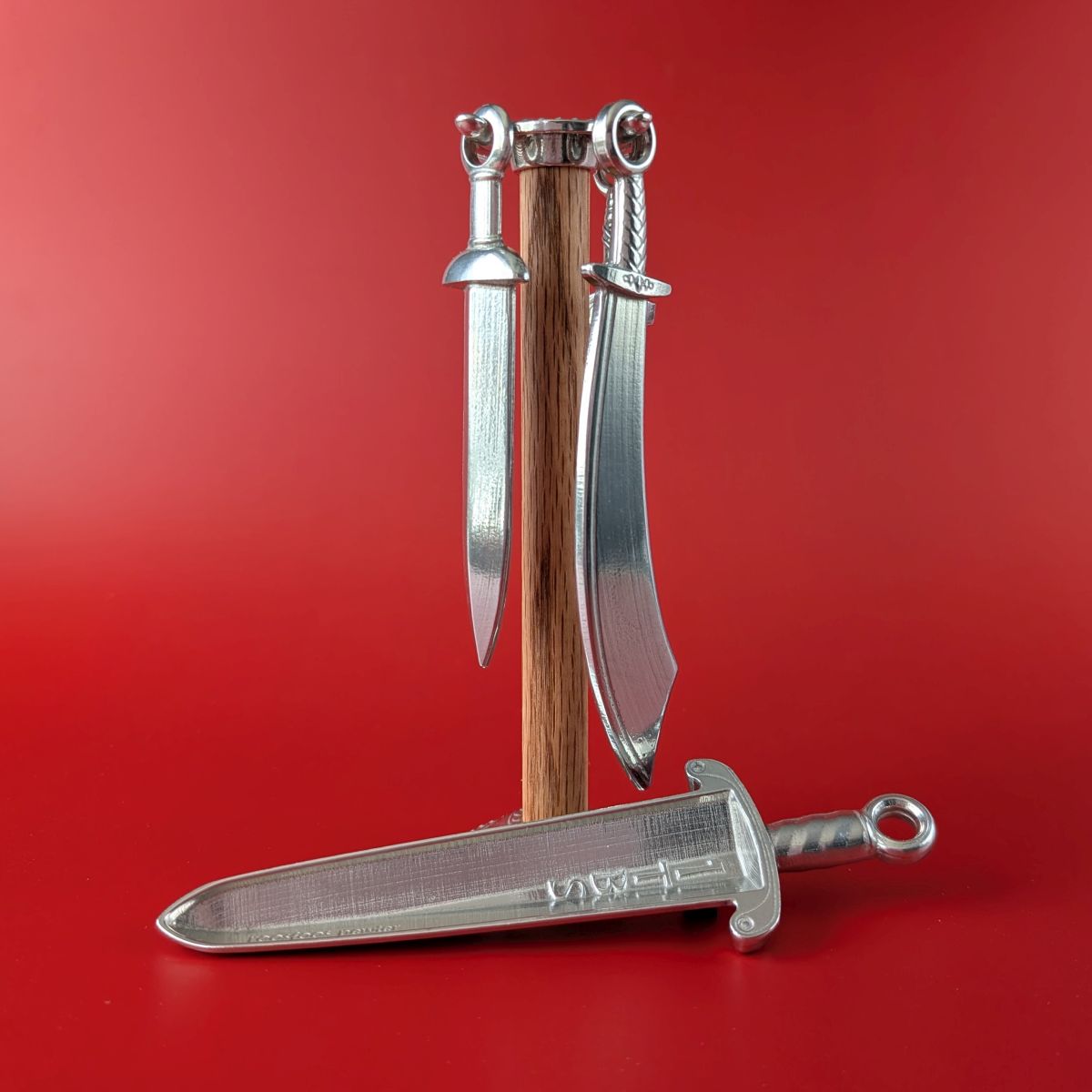 Pewter measuring spoons shaped like swords on wooden post