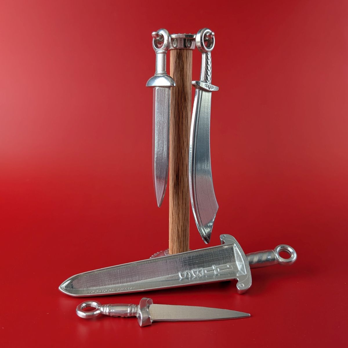 Pewter measuring spoons shaped like swords on wooden post