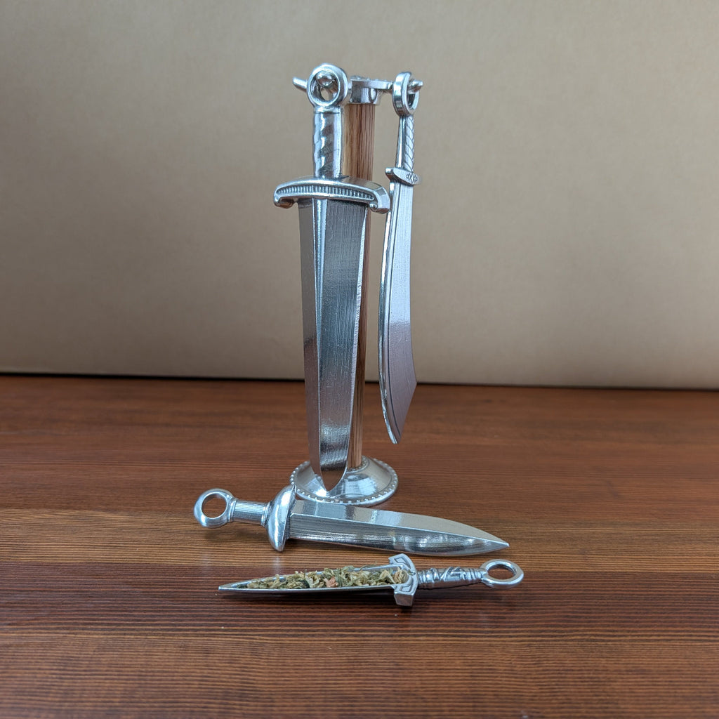 Set of silver dagger-shaped objects on a wooden surface with a beige background
