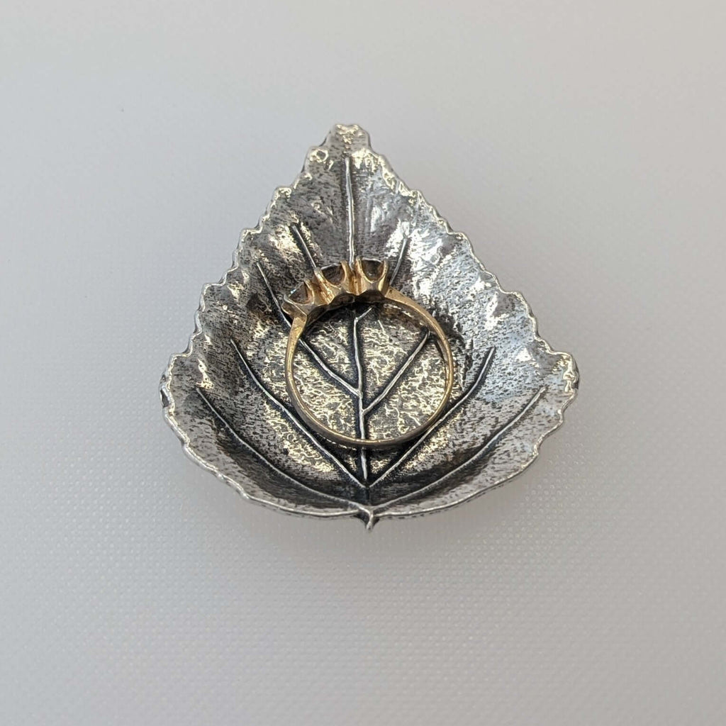 Pewter leaf dish on wood surface
