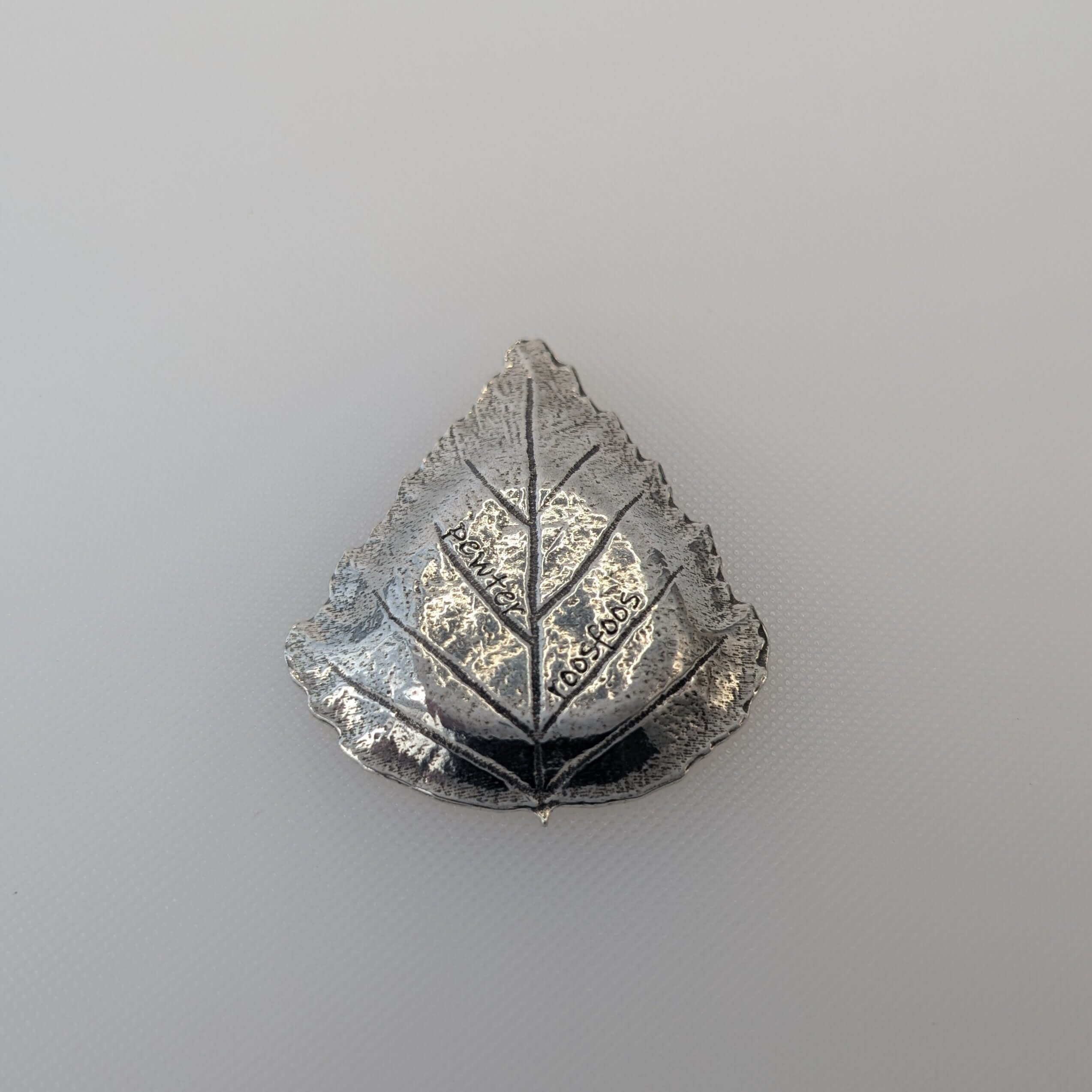 Pewter leaf dish on white surface