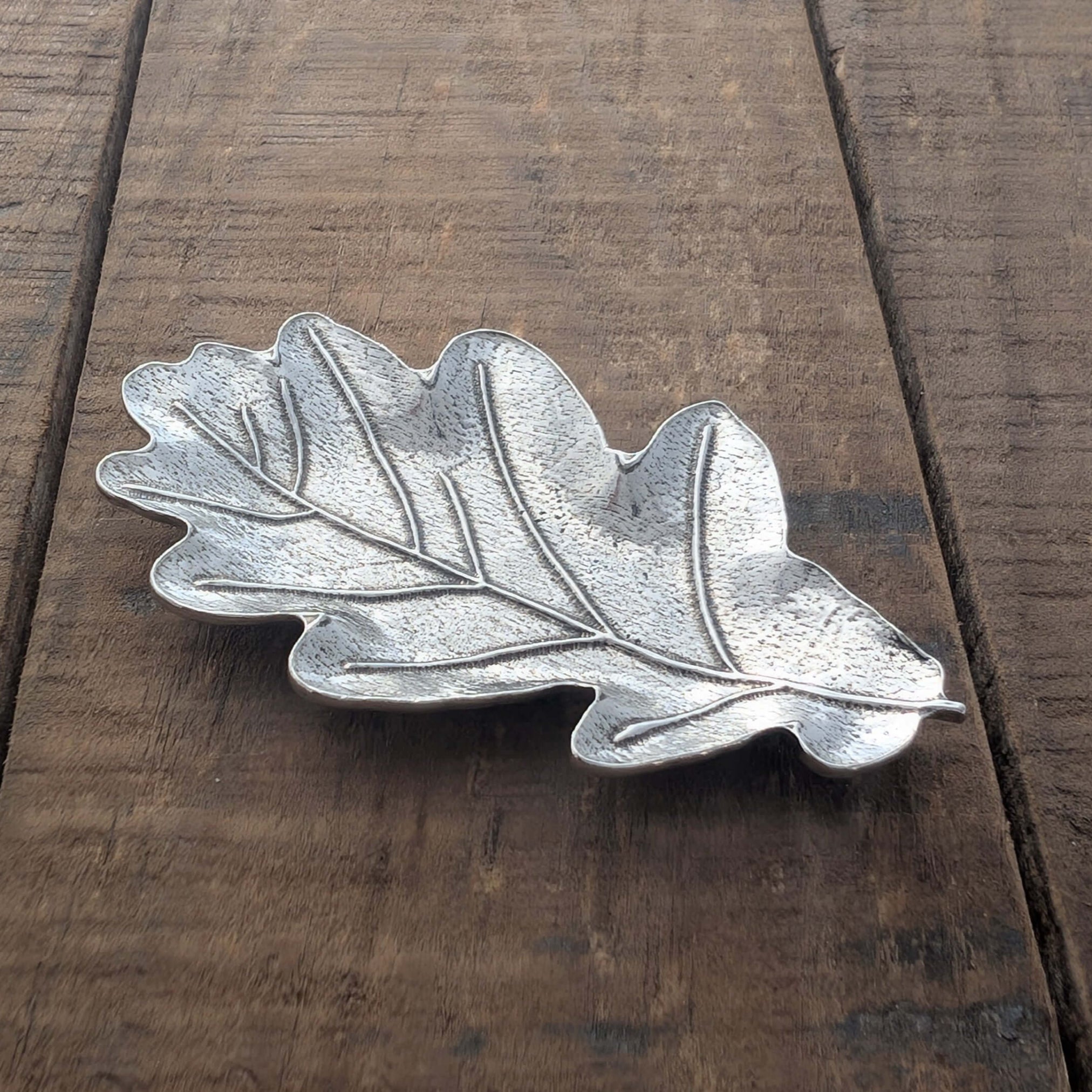 Pewter oak leaf ring dih on ood surface