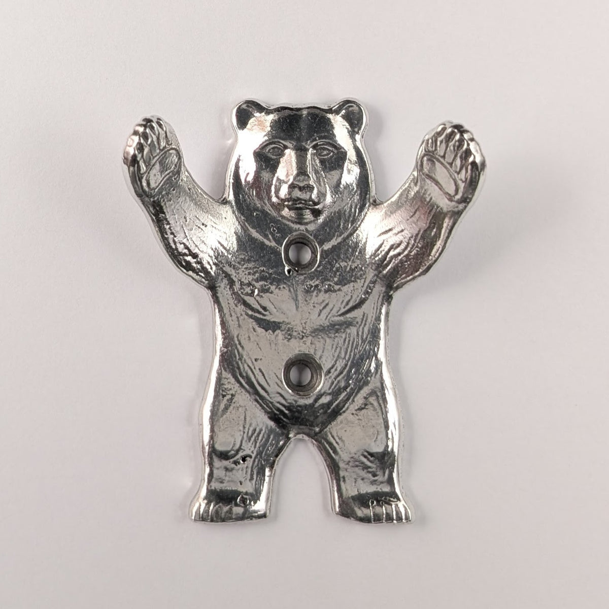Close-up of a pewter bear wall hook paw mounted on wood, different angle