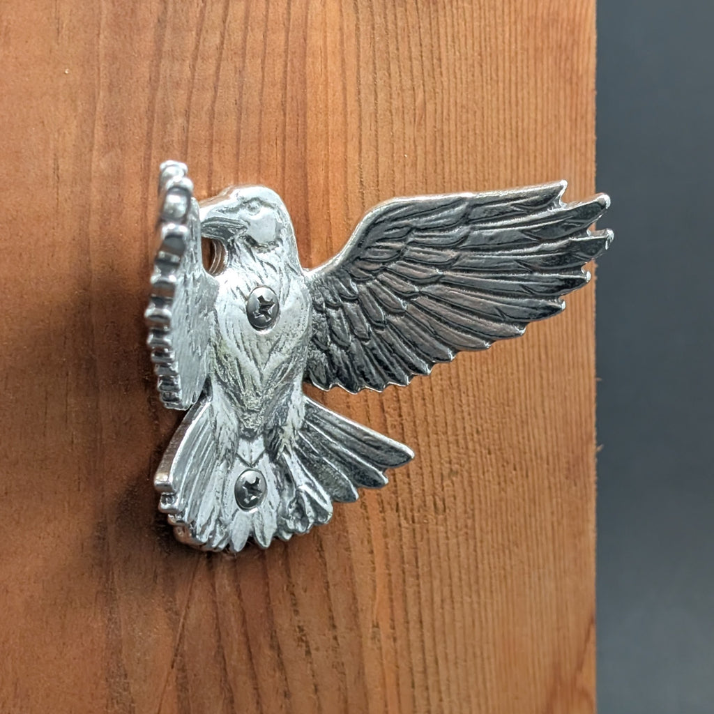 Close-up of a pewter crow wall hook showing wing and beak detail