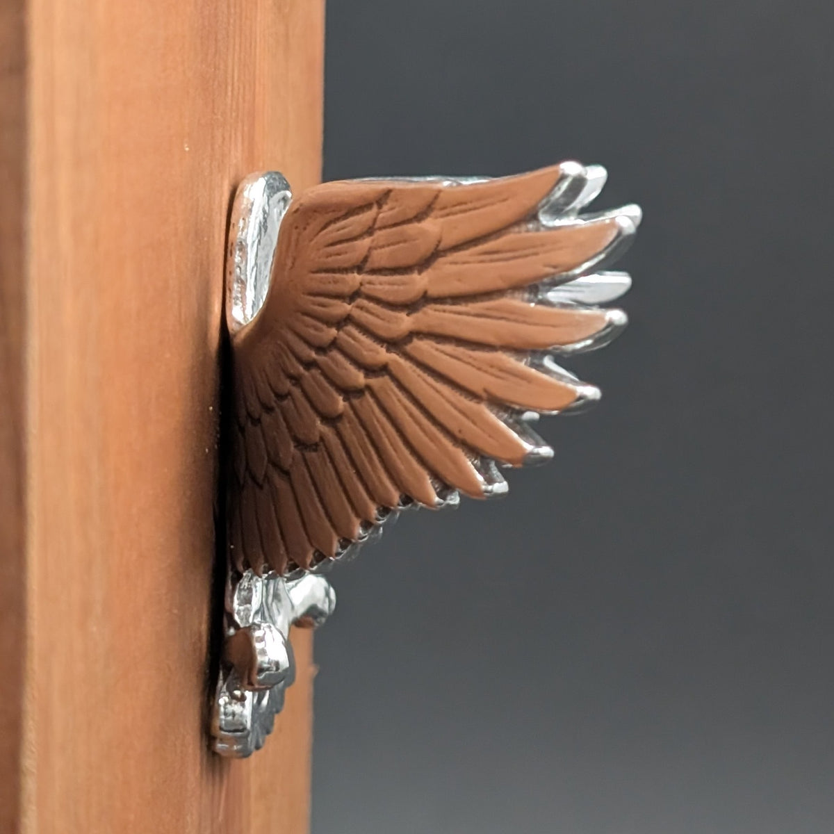 Close-up of a pewter eagle wall hook showing feather and wing detail