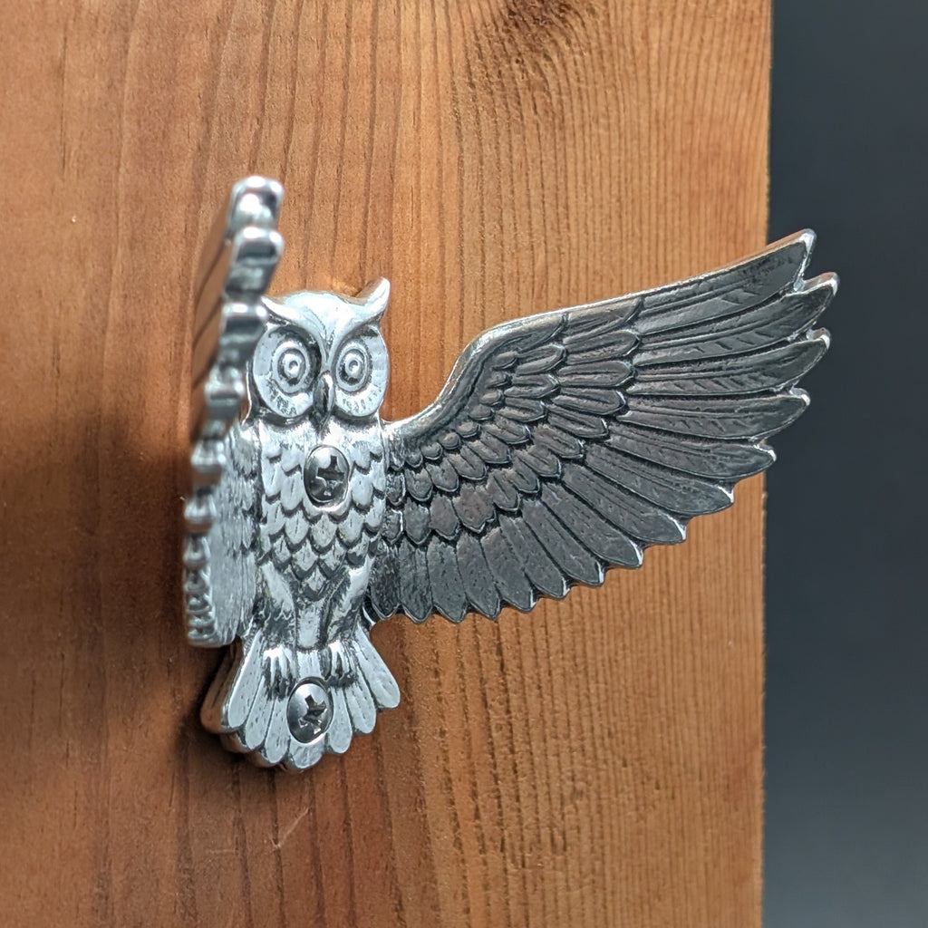 Pewter owl wall hook mounted on a wood board, angled close-up