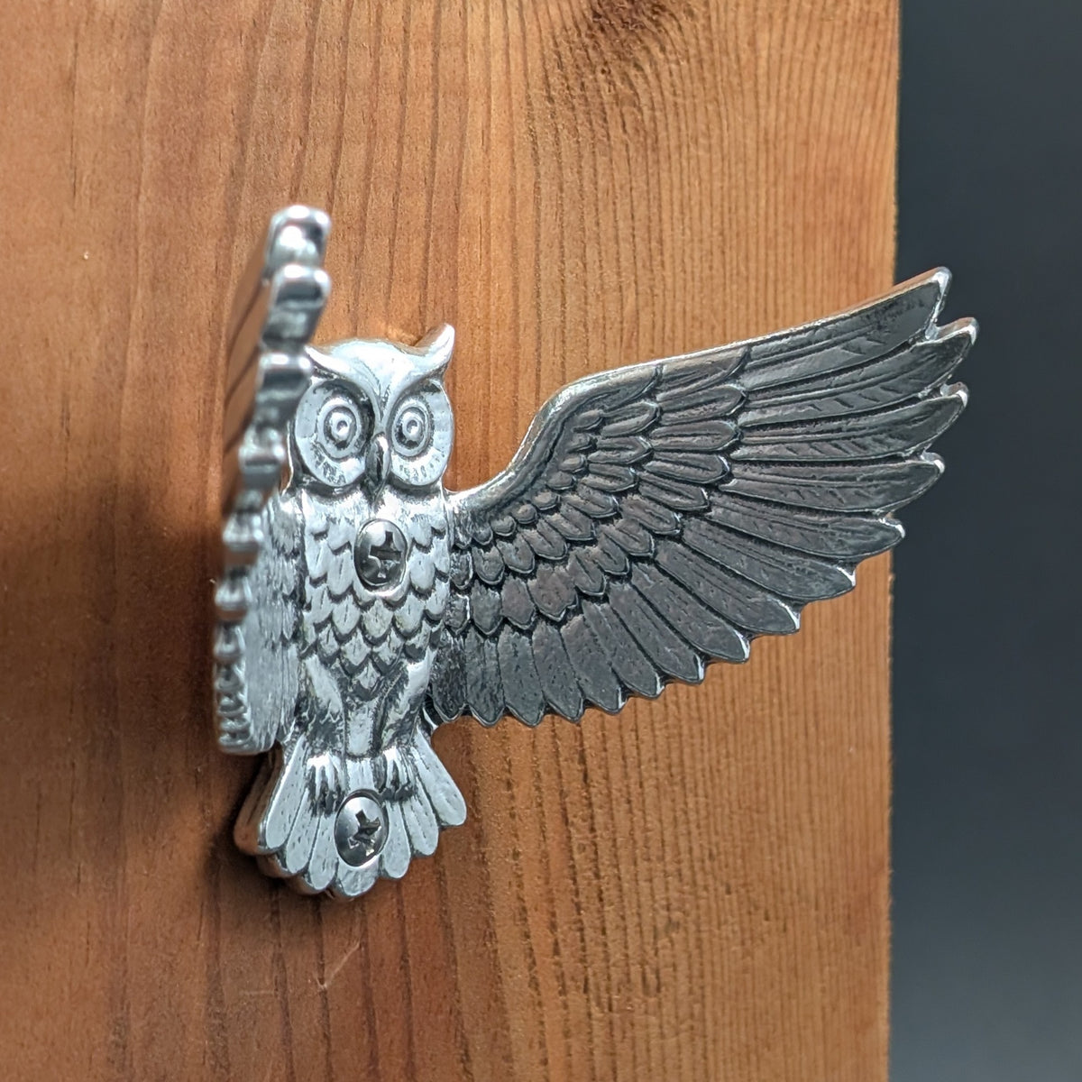 Pewter owl wall hook mounted on a wood board, angled close-up