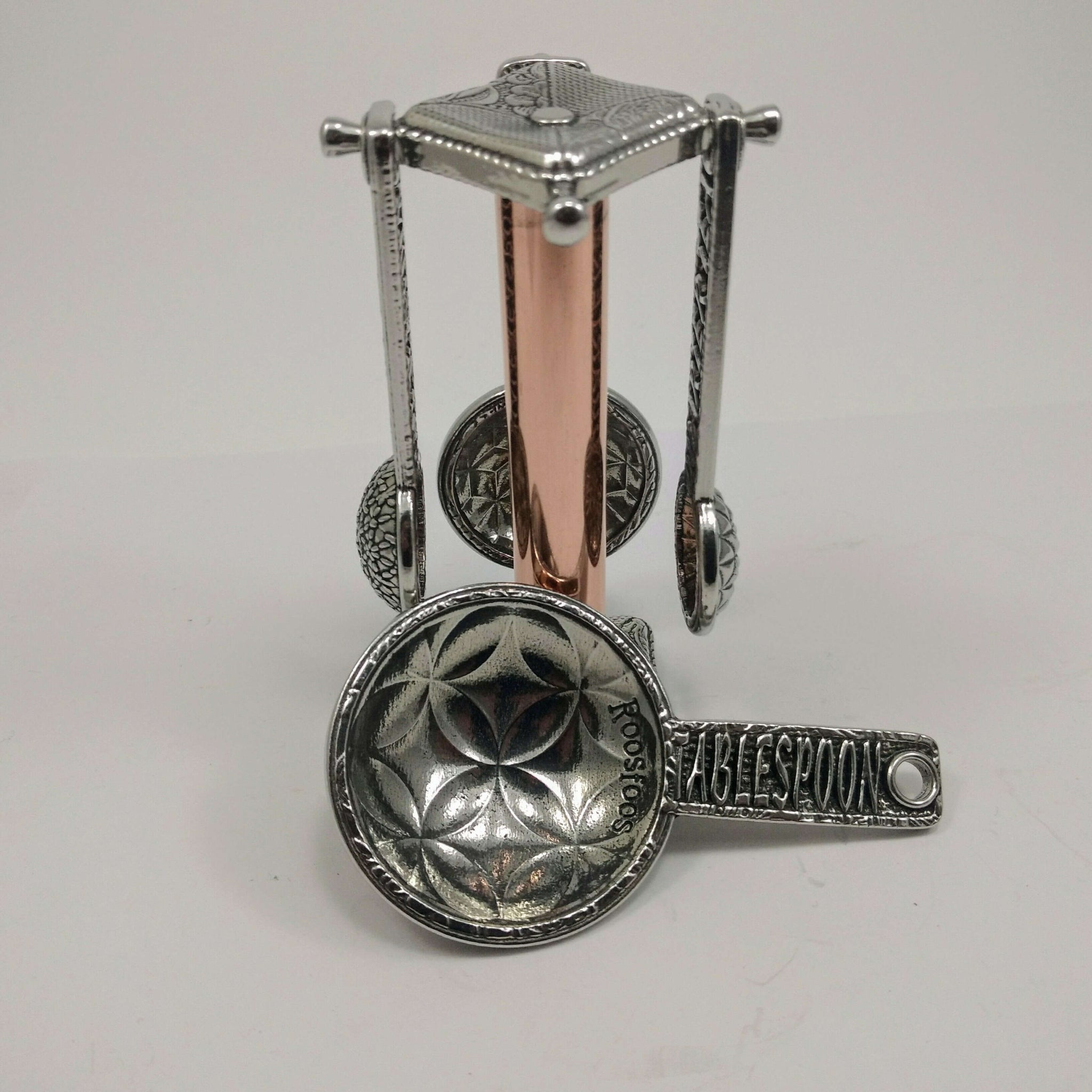 Pewter measuring spoons on copper stand