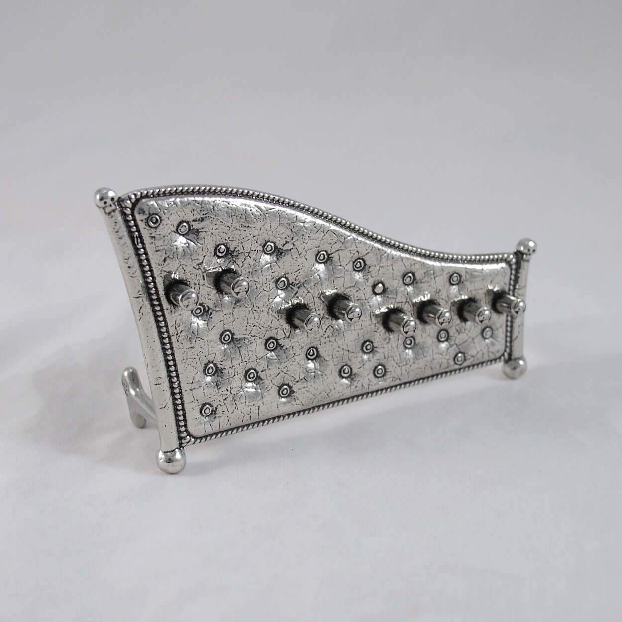 Display stand for skull measuring spoons, white background.